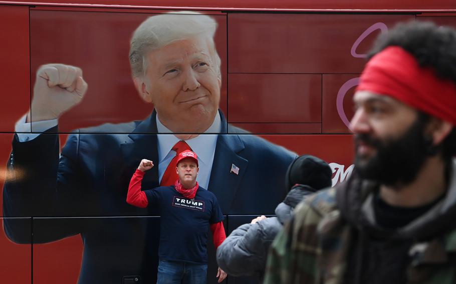Supporters of then-President Donald Trump pose in front of a bus parked in front of the Willard hotel as people gather at nearby Freedom Plaza on Jan. 5, 2021, to protest the election results. 
