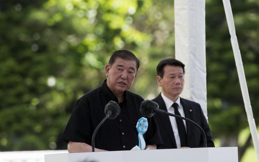 Japanese Prime Minister Shigeru Ishiba speaks at a podium during a ceremony.