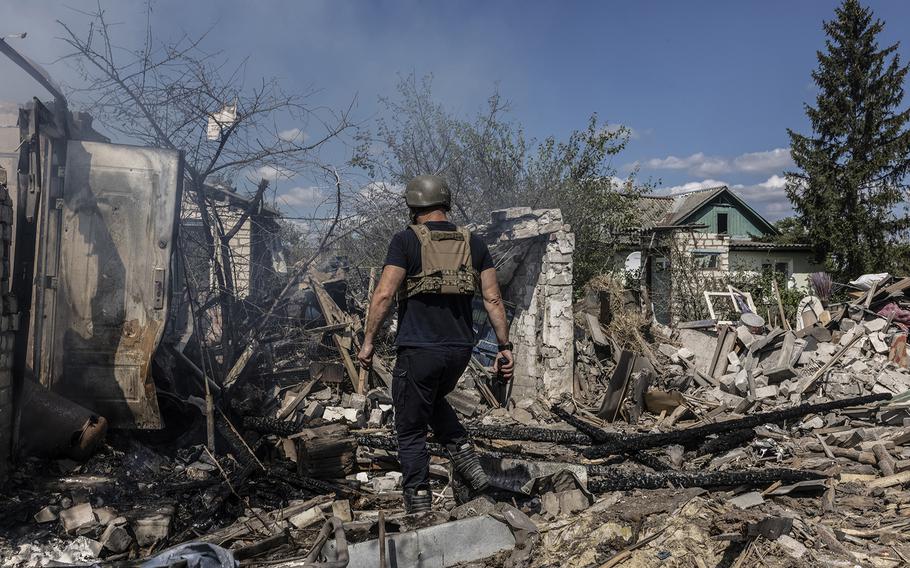 A firefighter works in the ruins of a home destroyed last month by Russian artillery in Kupyansk in the Kharkiv region. 