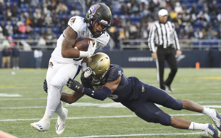East Carolina running back Keaton Mitchell is forced out of bounds by Navy's Michael McMorris during the second quarter of an NCAA college football game Saturday, Nov. 20, 2021, in Annapolis, Md.