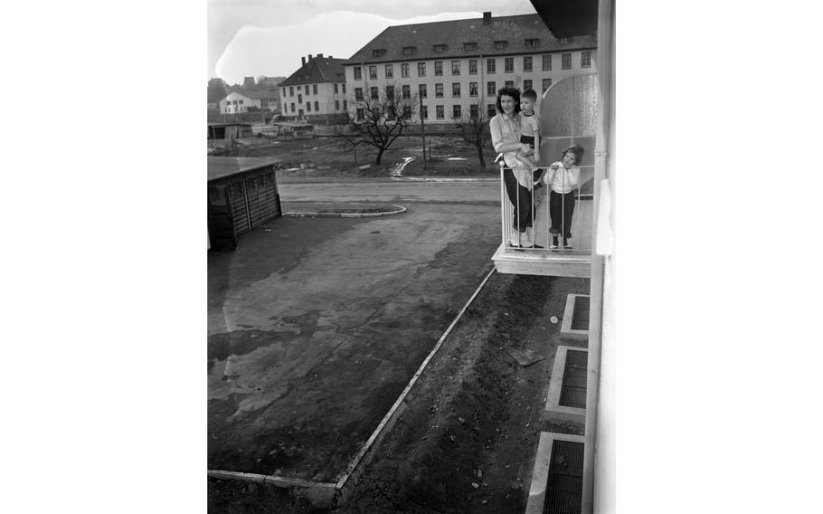 M. Sgt. William F. Garland, of Hq Co., 18th Inf., his wife, Helen, and their three daughters, Glenda Lee, 7, Billie Joe, 6, and Sandra Elizabeth, 3, stand on the balcony of their new apartment, one of the 156 newly constructed apartment units for service members and their families in Aschaffenburg. The roads and landscaping in the housing project have yet to be finished.