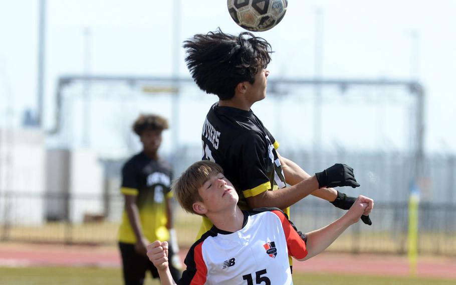 Kadena's Will Wetherill goes up to head the ball against Nile C. Kinnick's Talan Farrington during Saturday's Perry Cup Gold Group match. The Panthers won 2-0, capturing the group and championship by goal differential.