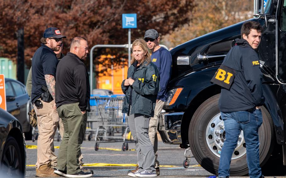 Members of the FBI gather in the parking lot of the Walmart in Chesapeake, Va., on Thursday.