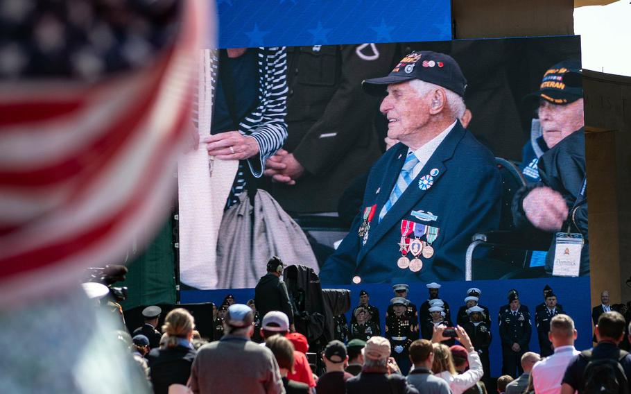 Spectators at Normandy American Cemetery watch as World War II veterans arrive at a ceremony to mark the 80th anniversary of D-Day, Thursday, June 6, 2024.