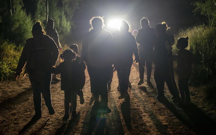 Undocumented immigrants walk toward a Customs and Border Patrol station after being apprehended at the U.S. border near Mission, Texas, on Feb. 10, 2021.