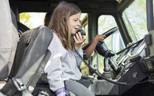 A student at Oaks Road Academy makes an announcement inside a P-19R Aircraft Rescue Fire Fighting vehicle, assigned to Marine Wing Support Squadron (MWSS) 271, during a career fair in New Bern, North Carolina, April 19, 2024. MWSS-271 and 2nd Low Altitude Air Defense (LAAD) Battalion participated in a career fair at Oaks Road Academy to engage with the local community. (U.S. Marine Corps photo by Staff Sgt. Daisha Ramirez)