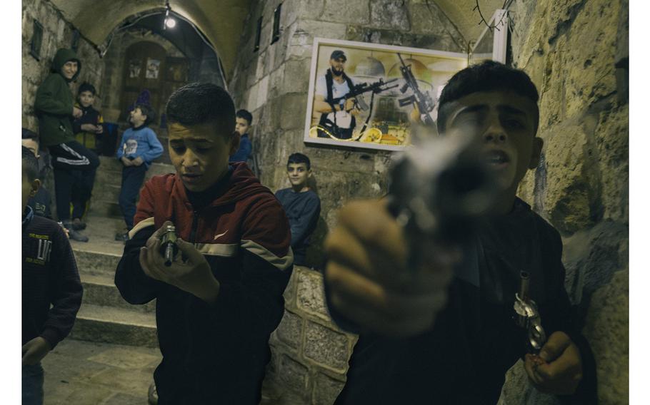 Palestinian children play with toy guns in front of the Nablus home of Wadi al-Hawah, a deceased co-founder of the Lions' Den militant group.