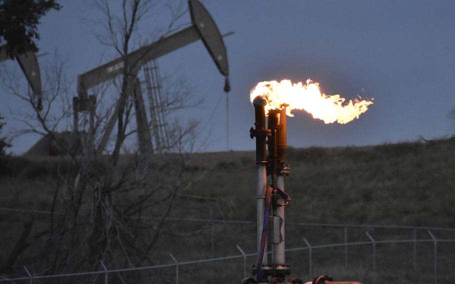 A flare to burn methane from oil production is seen on a well pad near Watford City, North Dakota, Aug. 26, 2021. A huge social and environmental policy bill passed by House Democrats includes a plan to impose a fee on emissions of methane, a powerful pollutant that leaks from oil and gas wells and contributes to global warming.