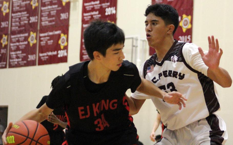 E.J. King's Nolan FitzGerald seeks a way around Matthew C. Perry's Kainalu Shiraishi during Friday's DODEA-Japan basketball game. The Samurai won 48-42.