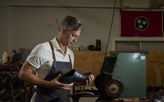 Heath Potter at work at his shoe repair business with the Tennessee state flag on the wall. Heath and his brother Trenton co-own the business as well as a sandal brand, Southern Polished, in Tennessee. 