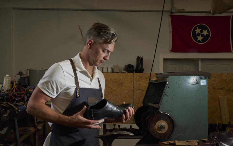 Heath Potter at work at his shoe repair business with the Tennessee state flag on the wall. Heath and his brother Trenton co-own the business as well as a sandal brand, Southern Polished, in Tennessee. 