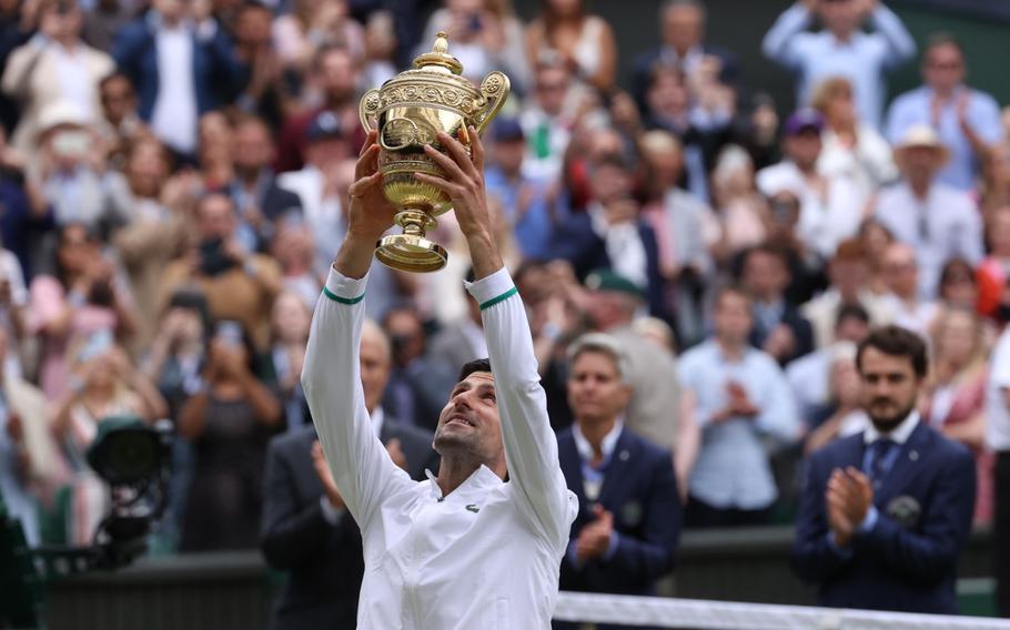 Novak Djokovic hoists the trophy after defeating Matteo Berrettini on Sunday at Wimbledon, England.