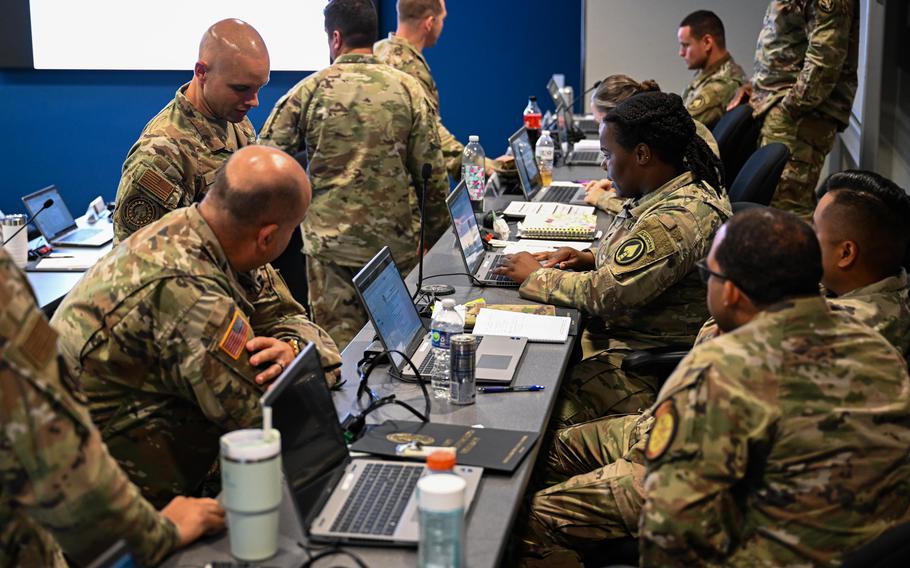 People on their computers at a row of desks