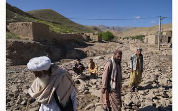 Residents who lost their homes, crops, and livestock in the flood zone walk through the destruction trying to get help from local Taliban police officers in Chesht-e-Sharif on May 10, 2024.