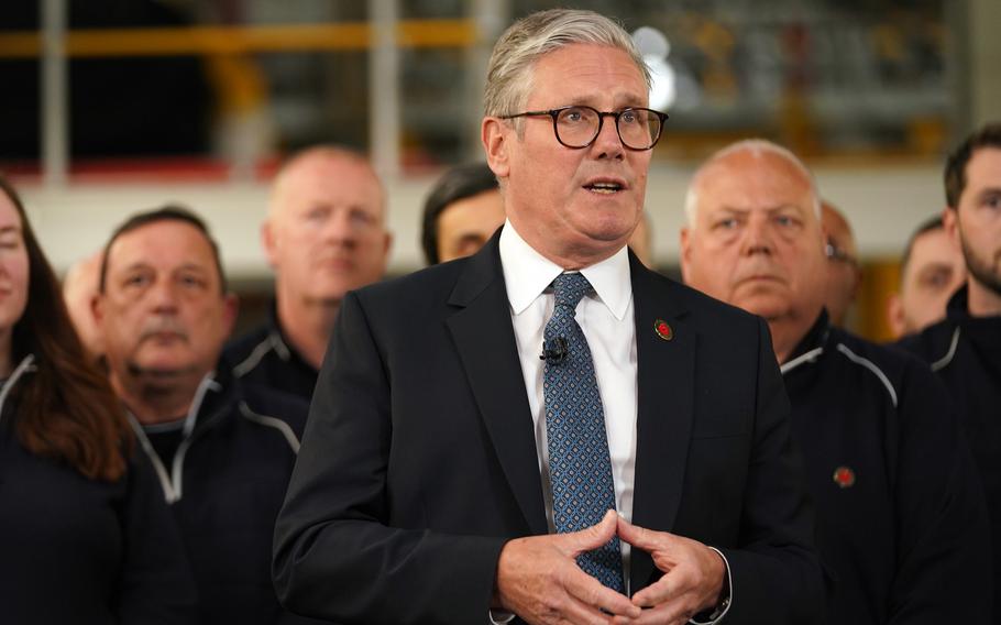 Keir Starmer speaks to a group at a car factory.