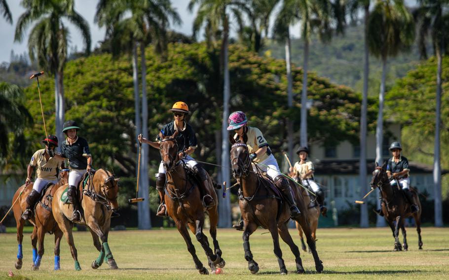 Several people on horses playing polo.