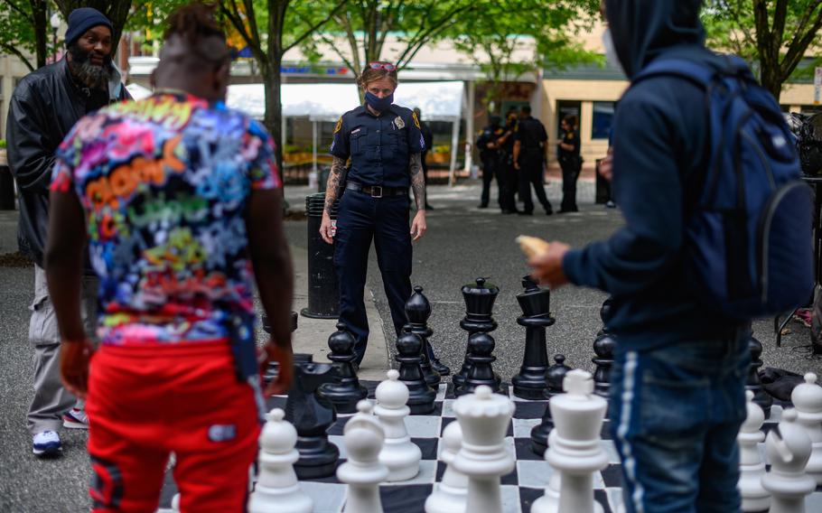 Pittsburgh police Sgt. Tiffany Costa of the Community Engagement Office plays chess with civilians in Market Square. 