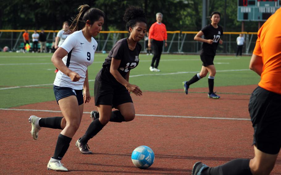 Osan‘s Clarice Lee and Daegu’s Samantha Jones chase the ball upfield during Friday’s DODEA-Korea girls soccer match. The Cougars won 3-0.