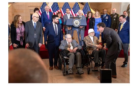 House Speaker Mike Johnson, R-La., shakes hands with Bernie Bluestein while presenting the Congressional Gold Medal at the U.S. Capitol in Washington, D.C. on March 21, 2024, during a ceremony recognizing the service of World War II Ghost Army veterans. Honored at the event along with Bluestein were Seymour Nussenbaum, seated in the wheelchair at left, and John Christman, standing second from left.