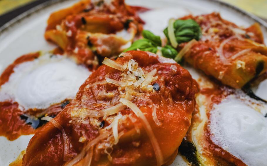 A plate of vegetarian homemade tortellini with ricotta -mozzarella filling and sun-dried tomato is served at Grifo Restaurant, in Kerzenheim, Germany, complete with cherry tomato cream and a drizzle of balsamic reduction.