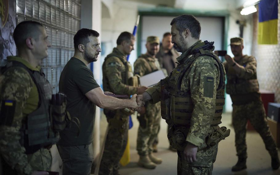 In this photo provided by the Ukrainian Presidential Press Office, Ukrainian President Volodymyr Zelenskyy, second left, praises servicemen close to the front line in Donetsk region, Ukraine, Sunday, June 5, 2022.