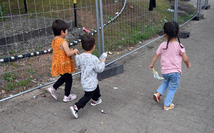 A little boy carries an empty bottle in the temporary living area for Afghan evacuees at Rhine Ordnance Barracks, Germany, Sept. 20, 2021. Volunteers have been instrumental in ensuring that Afghan women and children there have clean bottles for formula.