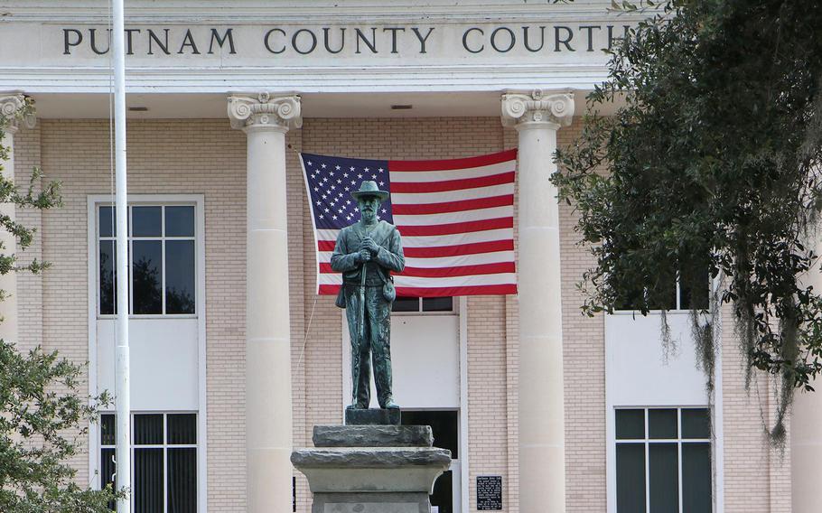 A bicyclist rides past the statue of a Confederate Civil War soldier on the grounds of the Putnam County Courthouse in Palatka. This week, the Putnam County Commission will consider an ordinance that would ban the removal of historical landmarks on public property, including the controversial Confederate monument.