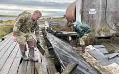 Alaska National Guard Staff Sgt. John Cunningham, left, and Airman 1st Class Reese Halford, both assigned to 176th Wing Maintenance Squadron, of Joint Task Force-Bethel clear storm debris from a boardwalk in Newtok, Alaska as part of Operation Merbok Response, Sept. 22, 2022. Approximately 100 members of the Alaska Organized Militia, which includes members of the Alaska National Guard, Alaska State Defense Force and Alaska Naval Militia, were activated following a disaster declaration issued Sept. 17 after the remnants of Typhoon Merbok caused dramatic flooding across more than 1,000 miles of Alaskan coastline. (Alaska National Guard photo by 1st Lt. Balinda O'Neal)