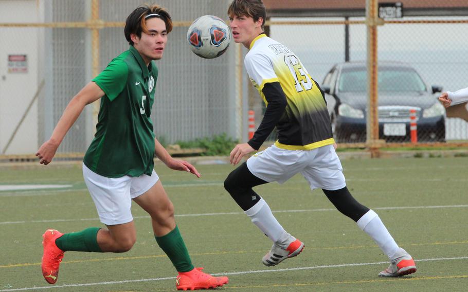 Kubasaki's Cody Wong and Kadena's Evan Davis eye the ball during Monday's Division I boys soccer match. The Panthers won 4-2.