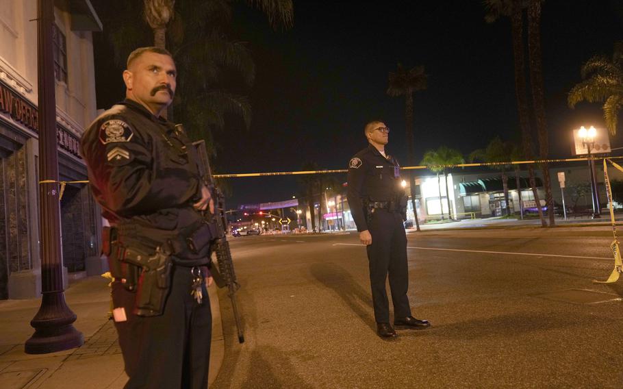 Two police officers stand guard near a scene where a shooting took place in Monterey Park, Calif., Sunday, Jan. 22, 2023. 