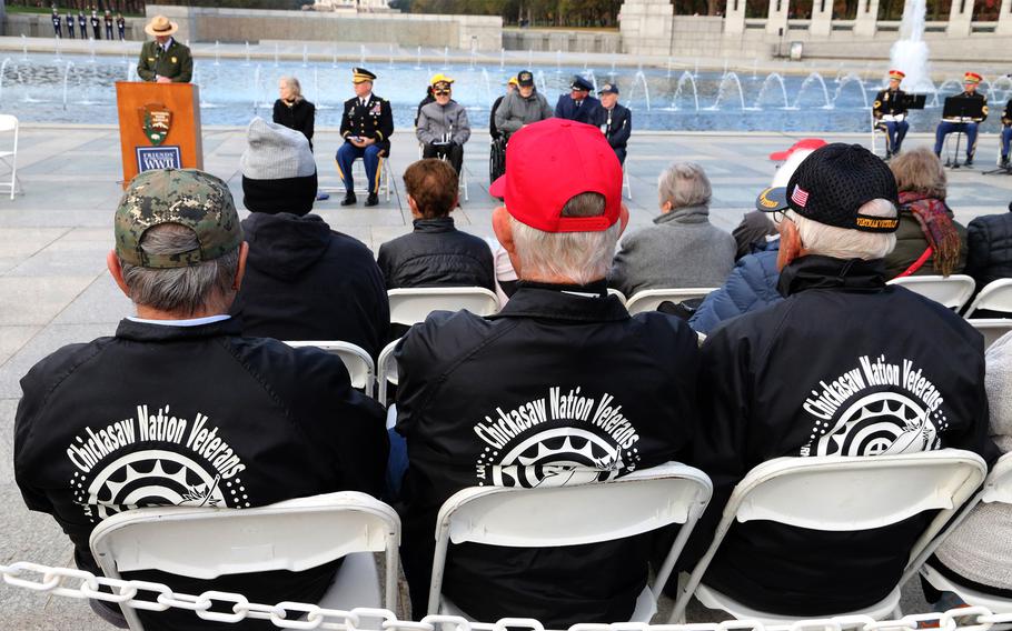 Visitors listen to Jeffrey Reinbold, souerintendent of the National Mall and Memorial Parks, before the Veterans Day ceremony at the National World War II Memorial in Washington, November 11, 2023.