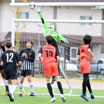 Matthew C. Perry keeper Kirby Kendrick gets a fingertip on a Nile C. Kinnick corner kick during Saturday's DODEA-Japan soccer match. The Red Devils won 5-0.