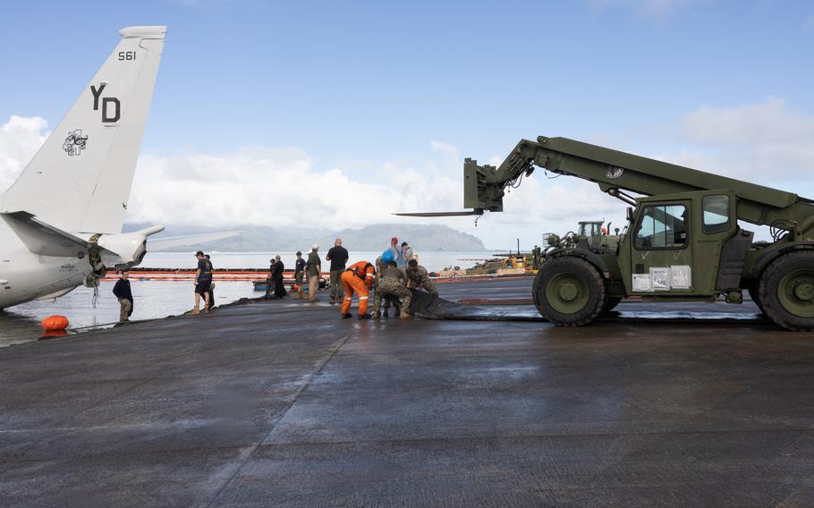 Private industry diving and salvage experts working alongside U.S. Navy sailors and Marines coordinate the placement of inflatable salvage roller bags as they position the U.S. Navy P-8A Poseidon for extraction from waters just off the runway at Marine Corps Air Station Kaneohe Bay, Marine Corps Base Hawaii, Dec. 2, 2023. 