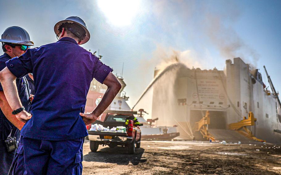 Coast Guard members discuss response operations to a fire on the motor vessel Grande Costa D’Avorio in Port Newark, N.J., on July 6, 2023. Marine fire fighting specialists are actively conducting fire suppression both from the pier and on the water. 