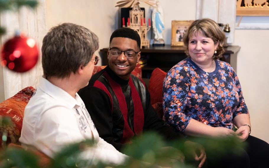 Army Spc. Lamar Porter, center, spends time with Alexander and Tina Schweitzer at their home in Primstal, Germany, on Christmas Day 2023. The Schweitzers hosted Porter as part of a program that pairs single soldiers with German families for the holidays.