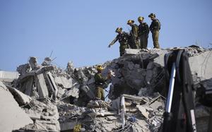 Israeli security forces inspect destroyed houses that were struck by a missile fired from Iran, in Rishon Lezion, Israel on Saturday, June 14, 2025. (AP Photo/Ohad Zwigenberg)