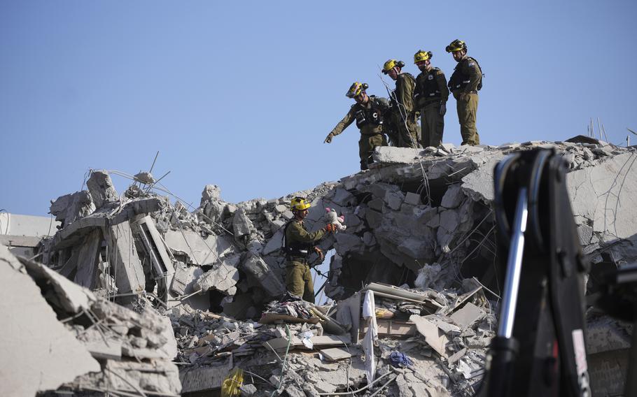 Israeli security forces inspect destroyed houses.