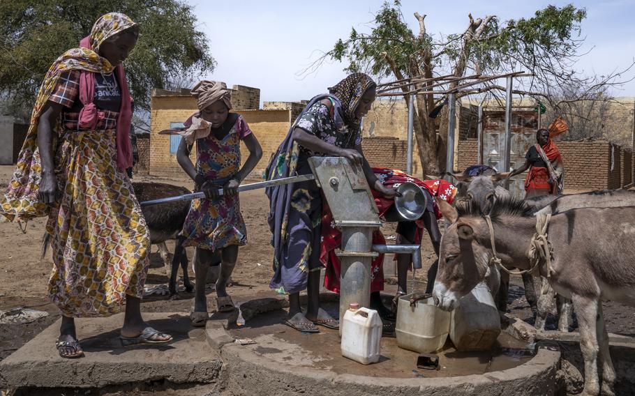 People fetch water from a borehole in the yard of the old primary school.