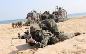 A South Korean marine takes his position as U.S. Marines from the 13th Marine Expeditionary Unit disembark from a landing craft during the Ssangyong Exercise in Pohang, South Korea, March 29, 2023. 