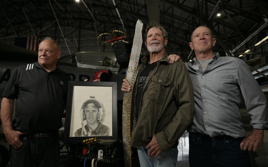 From left, brothers Mike, Bill and Dave Knobbe pose for a portrait with a photo of their father, Colorado Air National Guard Maj. William Hodgson, and a wrecked airplane part at Wings Over the Rockies Air and Space Museum in Denver on Wednesday, June 14, 2023. Maj. Hodgson crashed in Nebraska on an F-80 Jet on Feb. 26, 1958.
