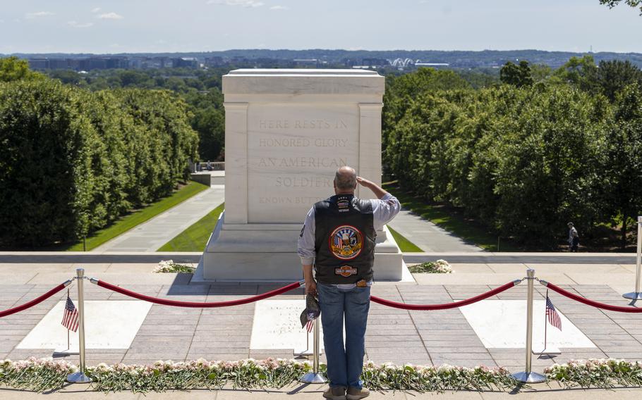 A veteran wearing a vest that says Army, All Gave Some, Some Gave All salutes.