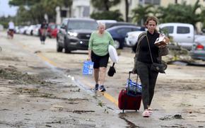 King Point residents leave with their belongings after an apparent overnight tornado spawned from Hurricane Ian at Kings Point 55+ community in Delray Beach, Fla., on Wednesday, Sept. 28, 2022. 