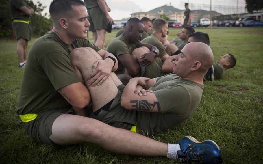 Marines at Marine Corps Base Hawaii do crunches during their physical fitness test in March 2017. The Corps is doing away with crunches as part of its fitness test and replacing them with planks.