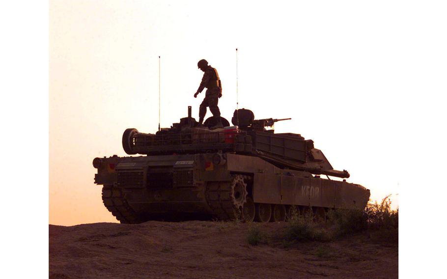 Pfc. Ray Martinez, with Alpha Company, 1st Battalion, 37th Regiment, walks on top of an Army M1A1 Tank position at Checkpoint Sapper, Kosovo, July 8, 2000.