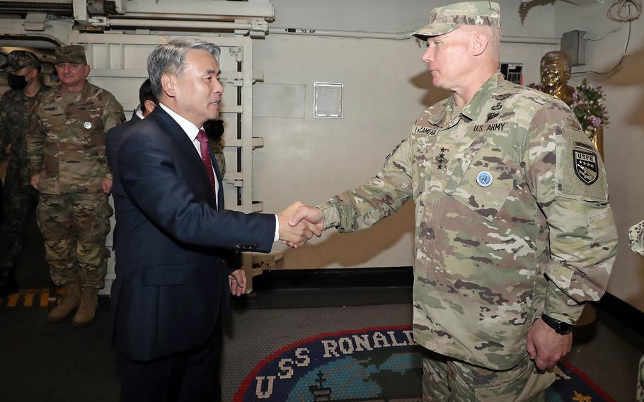 South Korean Defense Minister Lee Jong-sup greets the U.S. Forces Korea commander, Army Gen. Paul LaCamera, aboard the aircraft carrier USS Ronald Reagan in Busan, South Korea, Saturday, Sept. 24, 2022.