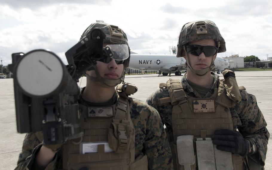 Members of the 11th Marine Expeditionary Unit stand security with an anti-aircraft missile as a Navy P-8 Poseidon is refueled during the Noble Fusion exercise at Marine Corps Air Station Futenma, Okinawa, Feb. 6, 2022. 