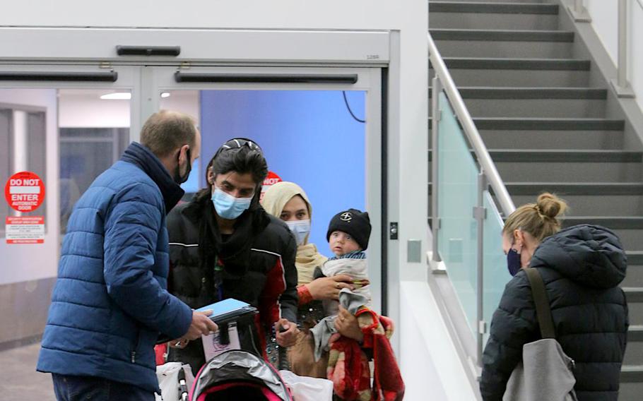 John Meyers, Catholic Charities director of refugee resettlement, left, and Kristina Hammell, right, greet a family of arrivals from Afghanistan at the Rochester International Airport, Minn., Tuesday, Nov. 2, 2021.