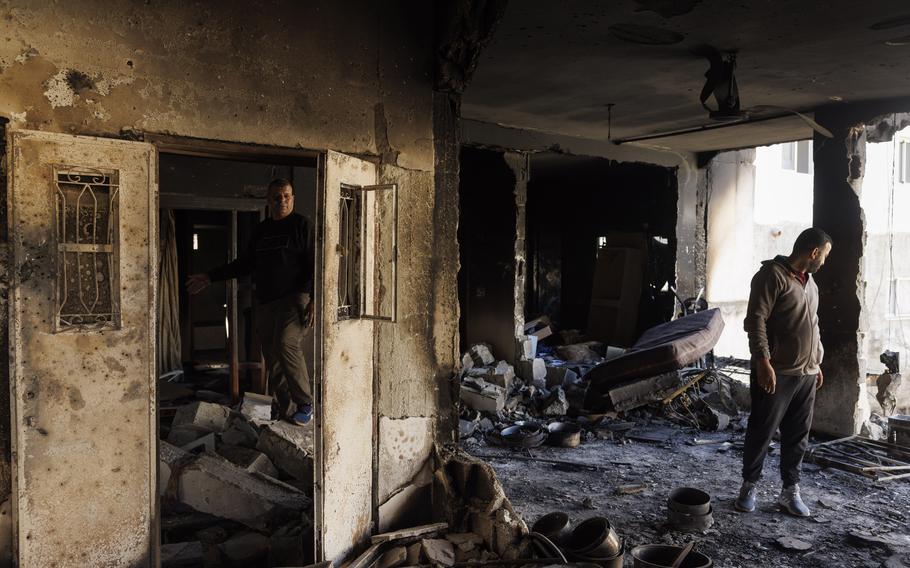A day after the Jan. 26, 2023, raid in Jenin, Palestinians stand in a home damaged during the fighting. 