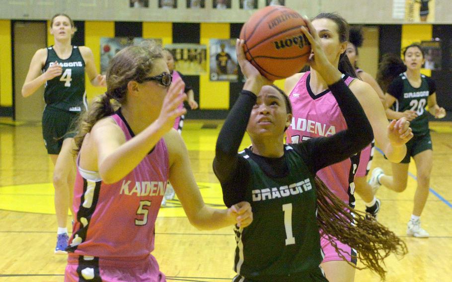 Kubasaki's Nevaeh Gilbert drives on Kadena's Marina Sawyer during Friday's Okinawa girls basketball game. The Dragons won 28-24, giving them a 3-1 season-series edge over the Panthers, their first in 20 seasons.