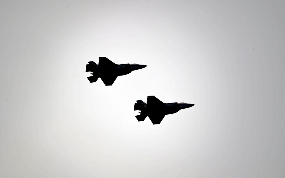 F-35 Lightning II planes are silhouetted in flight.